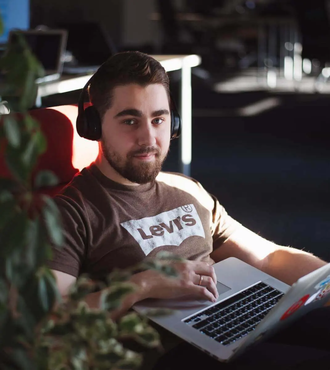 A Ronas IT team member wearing headphones and working on a laptop at the office