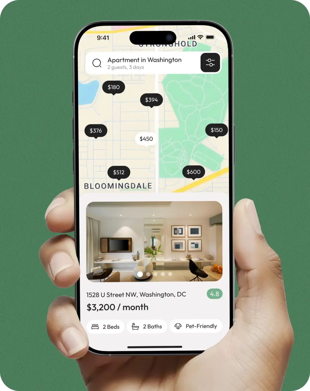 Hand holding a phone showing the property search map app for the US market.