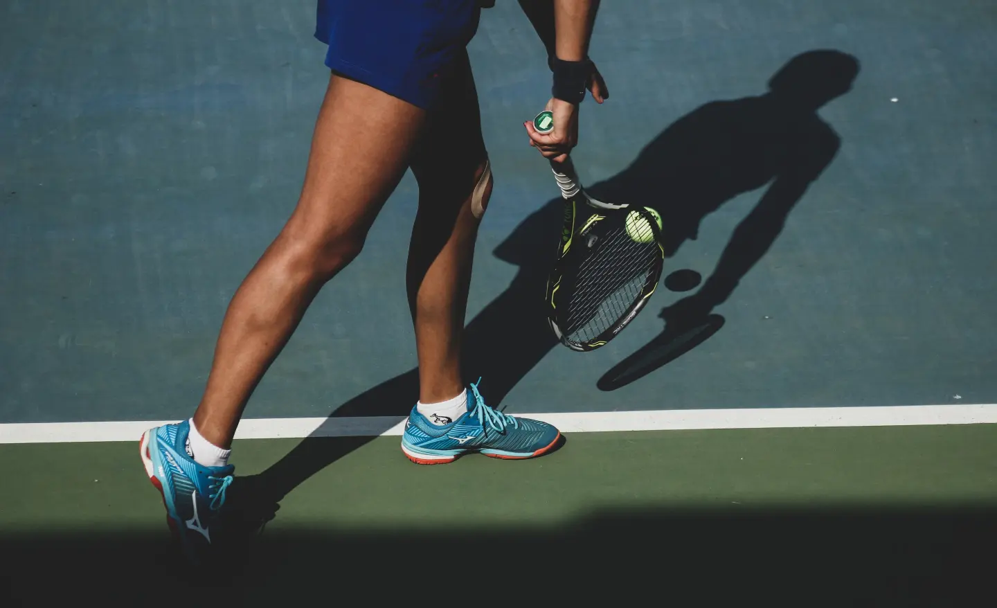 Photo of a runner's legs and sneakers in motion on a track.