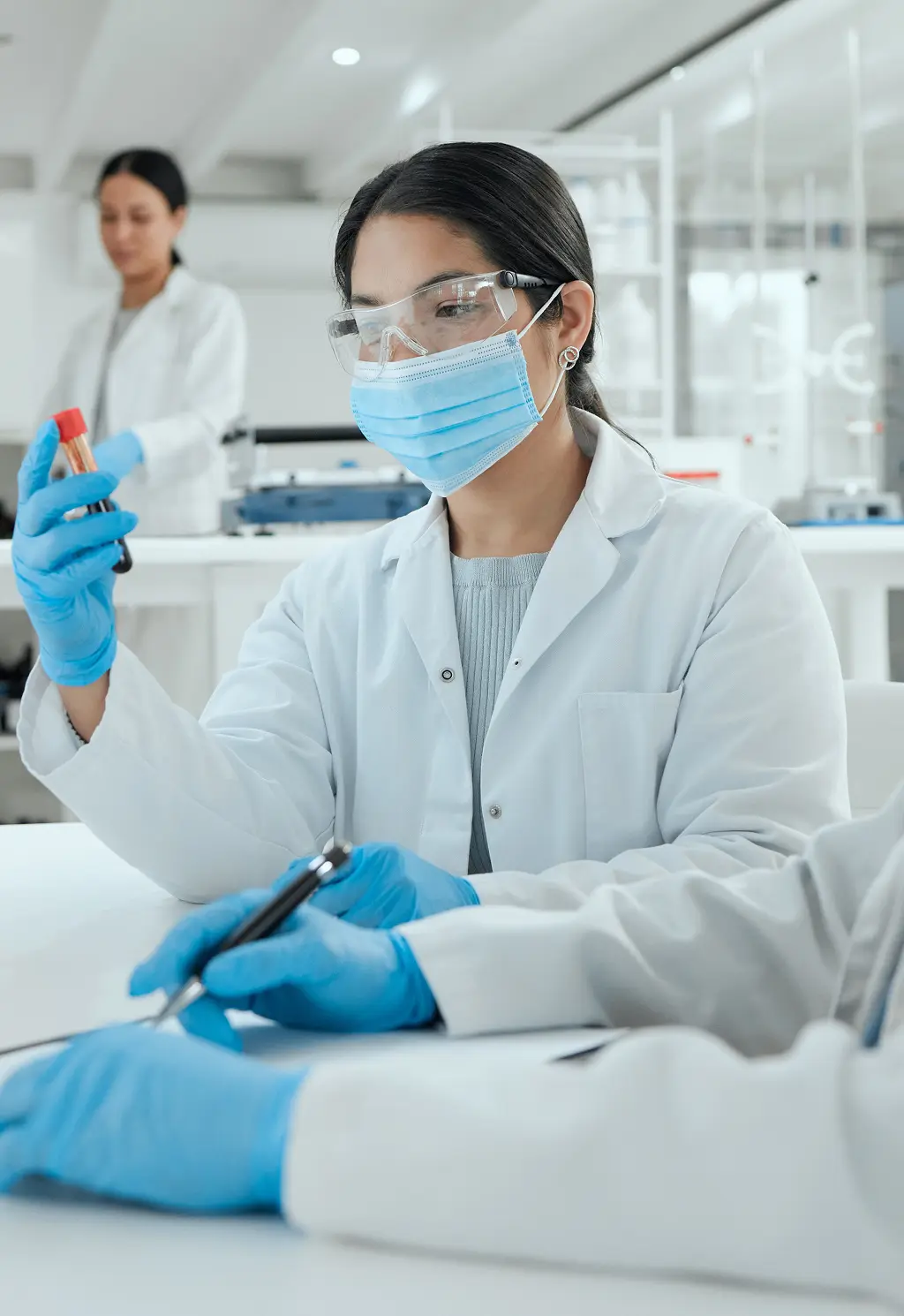 Lab technicians in white coats working in a clinical laboratory.