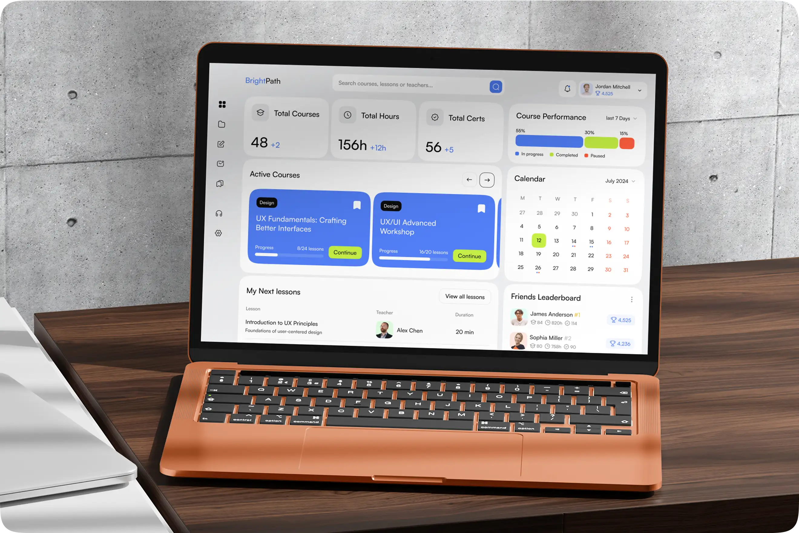 Laptop on a wooden desk displaying the learning platform dashboard.